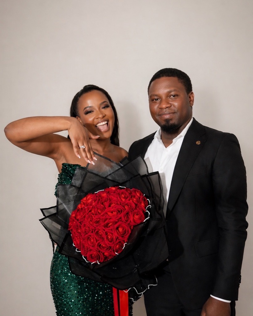Engagement-style portrait with emerald dress and red rose bouquet