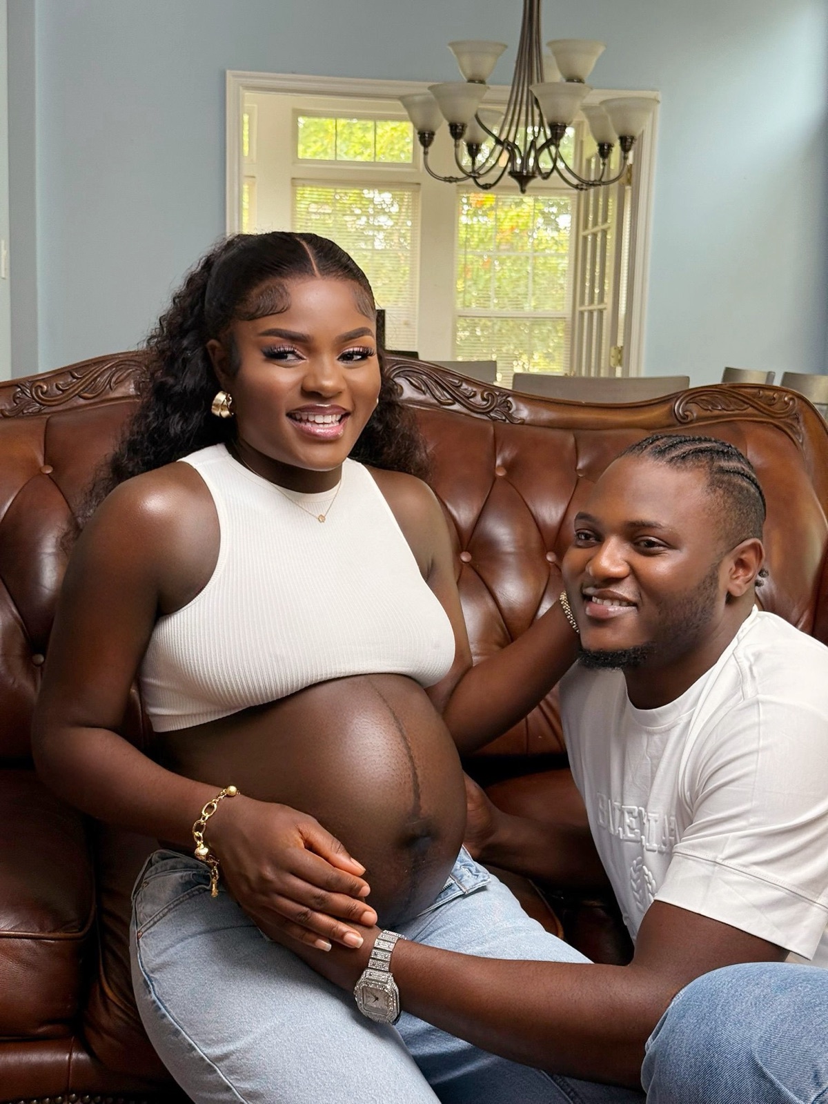 Expecting couple on a leather sofa